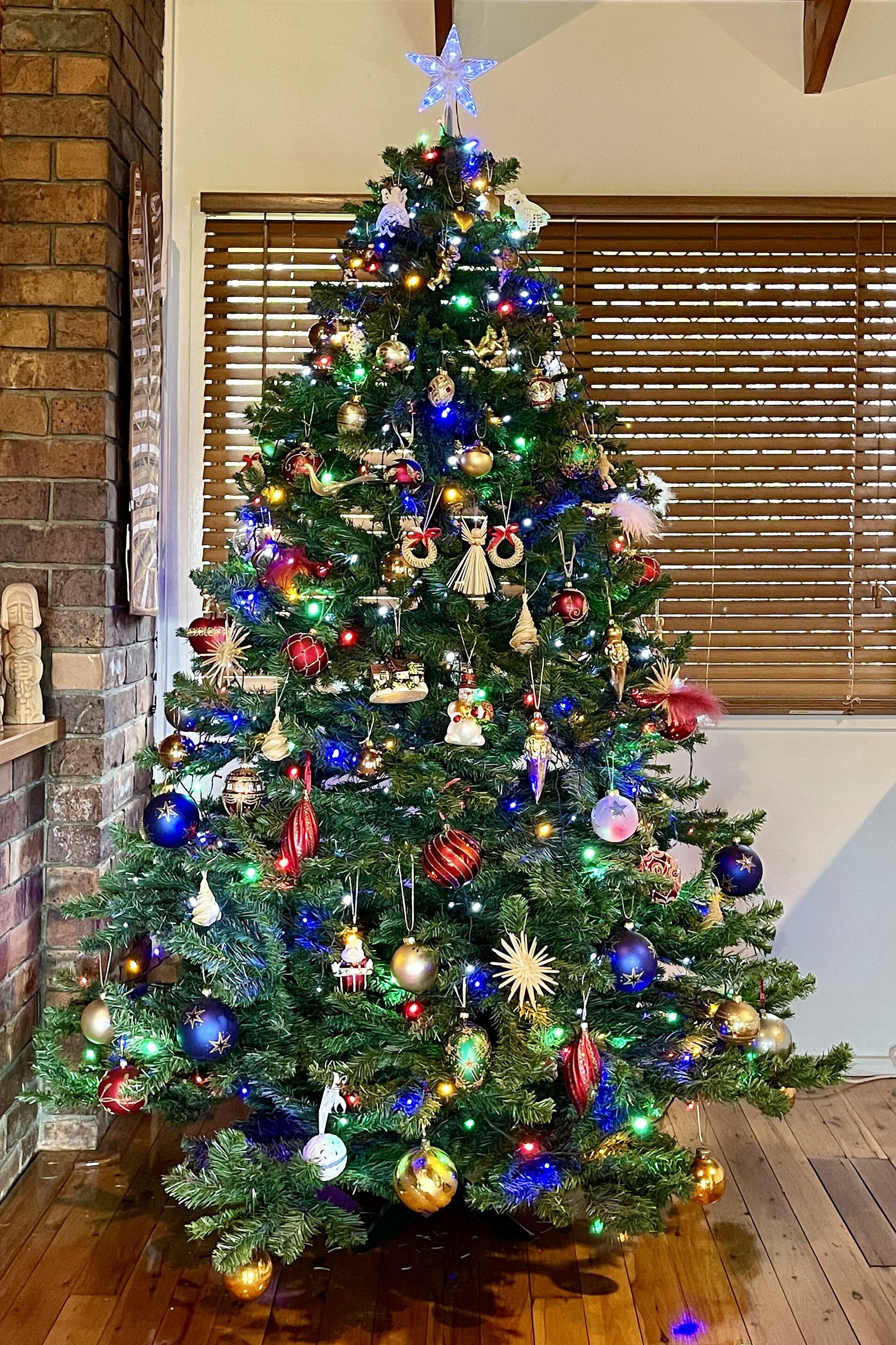 A star tree topper crowning a decorated Christmas tree — how to choose a Christmas tree topper